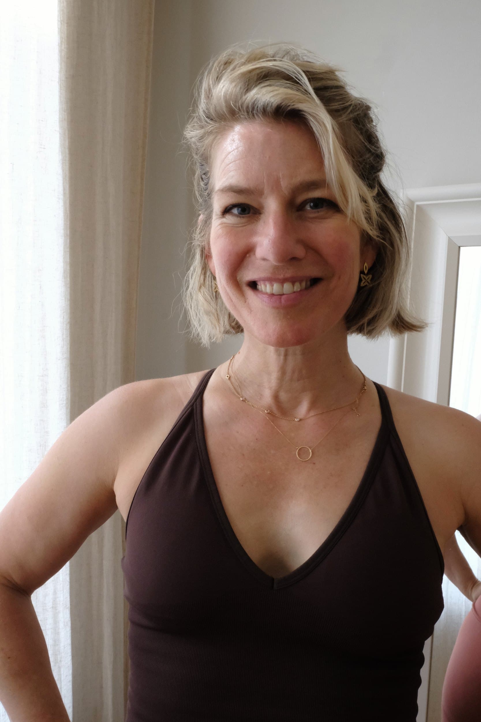 Portrait of Liv, the teacher behind Soma Pilates, smiling with her hands on her hips.